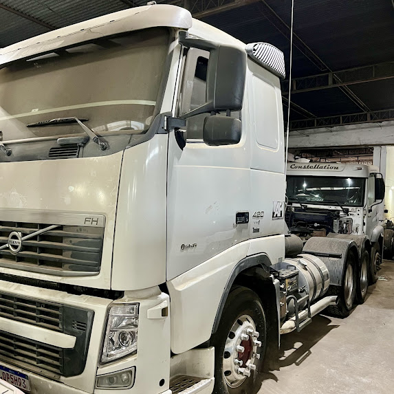 Mecânico inspecionando motor de caminhão Volvo FH na JL Mecatrônica Diesel em Três Rios, RJ